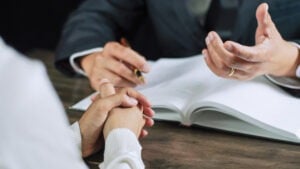 Closeup of the hands of a sex crime lawyer in Houston and their client discussing legal options.